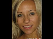 Candy is sited on a sofa, legs appart and looking at you