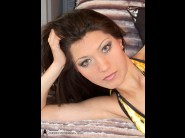 Nikita bulgaria is sited on a sofa, legs appart and looking at you